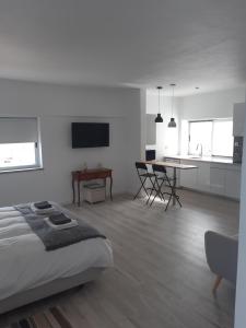 um quarto branco com uma cama, uma mesa e uma cozinha em CasaDuarte "NAU Deluxe Studio" em Lagos