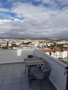 una mesa y sillas en un balcón con vistas en CasaDuarte "NAU Deluxe Studio" en Lagos