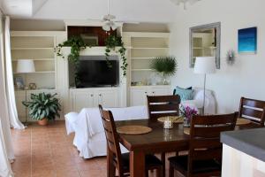 uma sala de jantar com uma mesa e uma televisão em Palm Point Loft em Turtle Cove