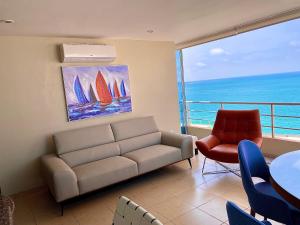 a living room with a couch and a view of the ocean at CÓMODO APARTAMENTO CON VISTA AL MAR. in Salinas +3 photos