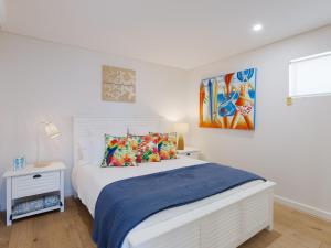 a bedroom with a bed and a painting on the wall at The Shoal 104 linen included and under 200m to beach in Shoal Bay