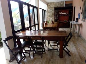 a dining room with a wooden table and chairs at Pousada Arco-Íris in Guarujá