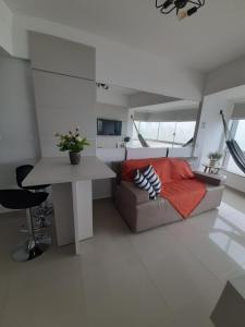 ein Wohnzimmer mit einem Sofa und einem Tisch in der Unterkunft Apto com vista deslumbrante, com piscina e garagem! in Balneário Camboriú