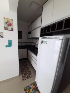 eine Küche mit weißen Schränken und einem Kühlschrank in der Unterkunft Apto com vista deslumbrante, com piscina e garagem! in Balneário Camboriú