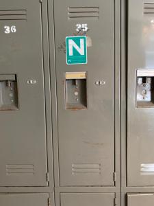 a row of metal lockers with a sign on them at Vancouver Backpacker House in Burnaby