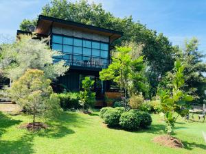 Baan Suanfah Kiangdao في نان: منزل به حديقة بها اشجار وشجيرات