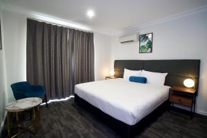 um quarto de hotel com uma cama, uma mesa e uma cadeira em Littomore Suites Bathurst em Bathurst