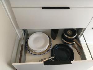 a cabinet with plates and utensils in it at Petes Place in Arthur's Pass