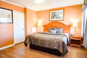 um quarto com uma cama grande e paredes cor-de-laranja em Economy Inn Beebe em Beebe