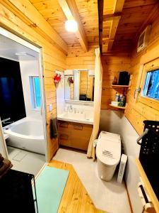 a bathroom with a toilet and a tub in a cabin at あかがね荘 in Sumino