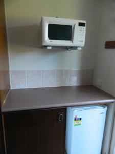 a microwave oven sitting on top of a kitchen counter at Coachman Motel in Toowoomba