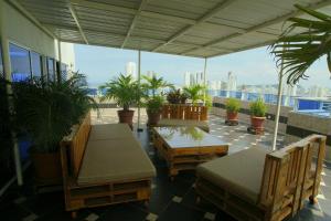 a patio with chairs and tables and potted plants at Apartamentos Bacanos in Cartagena de Indias