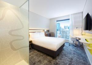 a hotel room with a bed and a desk and a window at Holiday Inn Express Brisbane Central by IHG in Brisbane