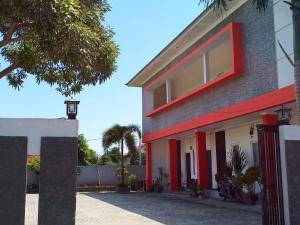 una casa con adornos rojos y una valla en Fidelia Homestay Palu Mitra RedDoorz en Biromaru