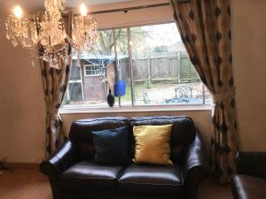 a black leather couch sitting in front of a window at Pendleton in Peterborough