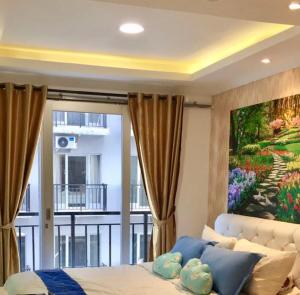 a bedroom with a large painting on the wall at Apartment Grand Asia Afrika Tulip Bandung in Bandung