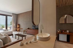 ein Wohnzimmer mit einem Bett und ein Badezimmer in der Unterkunft Chula Beach Resort in Khanom + 32 Fotos