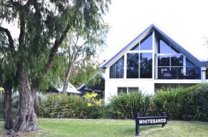 a white house with a sign in front of it at Whitesands in Dunsborough