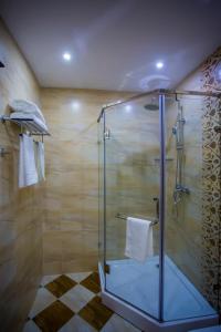 een douche met een glazen deur in de badkamer bij HOTEL AYNI in Doesjanbe