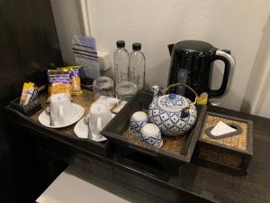 a shelf with a tea pot and other items on it at 99 The Gallery Hotel- SHA Extra Plus in Chiang Mai