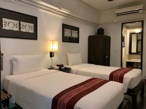 a hotel room with two beds and a mirror at 99 The Gallery Hotel- SHA Extra Plus in Chiang Mai