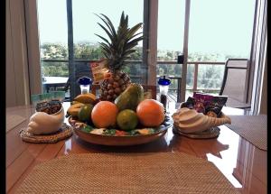 a table with a bowl of fruit on top of it at Adventure in Paradise in Haiku