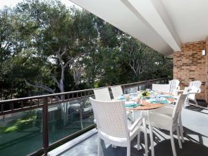 Una mesa y sillas en un balcón con vista. en Bay Parklands, 68 2 Gowrie Ave - Fully ducted aircon, wifi, pool, tennis court, communal spa, en Shoal Bay