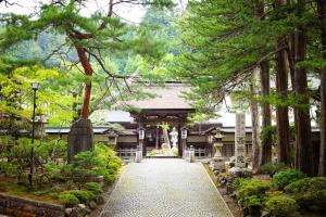 
a walkway leading to a forest filled with trees at Koyasan Saizenin in Koyasan
