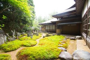 a building with a garden of rocks and moss at Koyasan Shukubo Saizenin in Koyasan