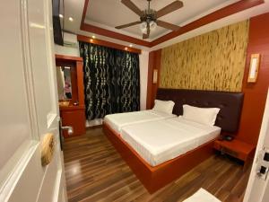 Niu Inn & Spa في هولهومالي: غرفة نوم بسرير ومروحة سقف