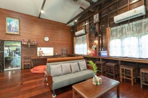 a living room with a couch and a table at Reuan Vilawan in Ratchaburi