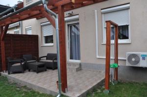 a pergola with chairs and a heater on a patio at Győrszem Apartman in Győr
