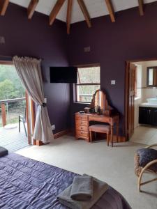 Schlafzimmer mit einem Bett, einem Schreibtisch und einem Waschbecken in der Unterkunft Masescha Country Estate in Plettenberg Bay