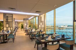 a restaurant with tables and chairs and a view of the water at Boudl Al Jubail in Al Jubail
