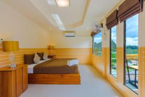 - une chambre avec un lit et une grande fenêtre dans l'établissement Railay Hilltop, à Railay Beach