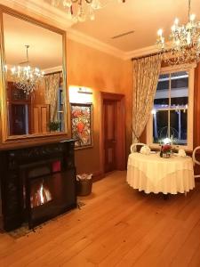 een woonkamer met een open haard en een spiegel bij Falcons View Manor in Knysna