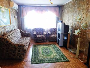 uma sala de estar com sofás e uma televisão e uma janela em Ильинская 3к посуточно почасово em Sumy