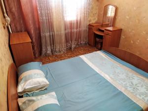 um pequeno quarto com uma cama e um espelho em Ильинская 3к посуточно почасово em Sumy
