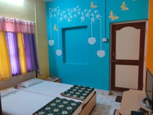 a bedroom with two beds and a blue wall at Hotel Ayodhya in Chiplun
