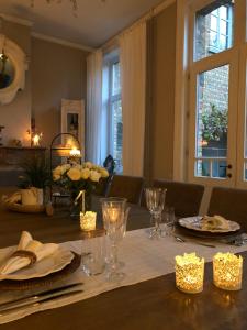 una mesa de comedor con platos y vasos. en B&B Le Cloître St Joseph, en Messines