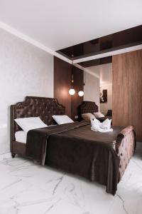 um quarto com uma cama grande e 2 almofadas brancas em Royal Tower VIP Smart Apartments 2 em Kiev