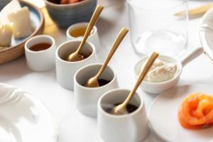 a table topped with white cups of food with wooden spoons at Dimora Cordero in Priocca