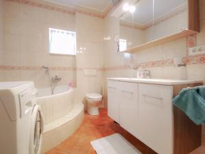 a bathroom with a tub and a toilet and a sink at Villa Marritanja in Podaca