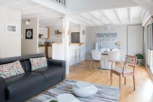 sala de estar con sofá negro y cocina en LE DUPLEX - Appartement familial cosy, en Saint-Nazaire