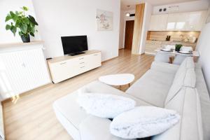 un soggiorno con divano bianco e TV di Apartament Solna C506 a Kołobrzeg