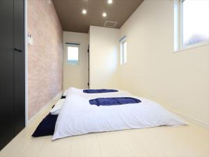 a bedroom with a bed with blue pillows on it at COTO Tokyo Koenji in Tokyo