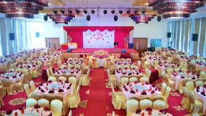 einen großen Bankettsaal mit Tischen und Stühlen in der Unterkunft Margherita Plaza Hotel in Bintulu