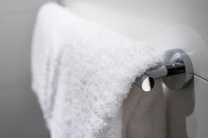 a white towel hanging from a white shower curtain at Motel One Bremen in Bremen