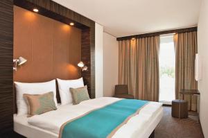 a hotel room with a large bed and a window at Motel One Bremen in Bremen