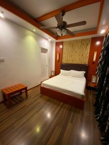 una camera con letto e ventilatore a soffitto di Niu Inn & Spa a Hulhumale